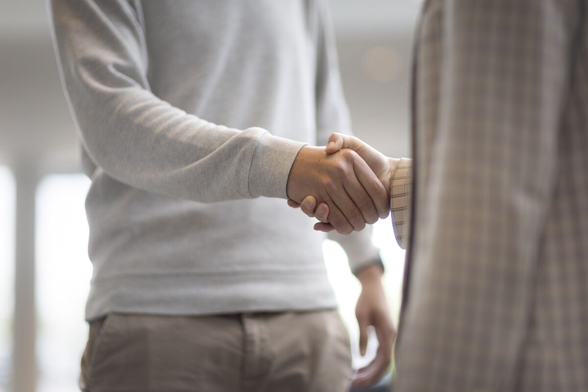 Man and woman shaking hands in office building.