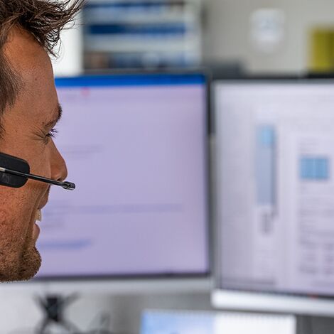 Customer Service operator with headset answering questions online.