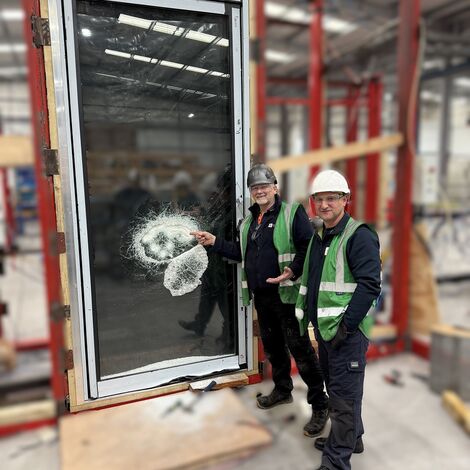 Two men stood in front of a door in a testing centre
