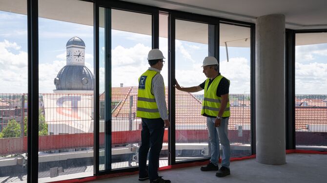 Reynaers specialists on building site, inspecting sliding doors.