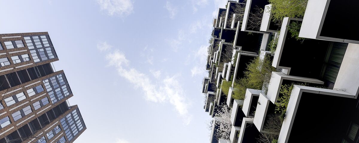 Blue sky green building as seen from below.