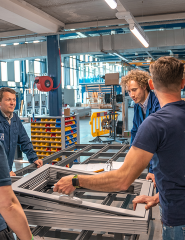 A group of people stood around in a workshop