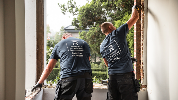 Two men installing a window