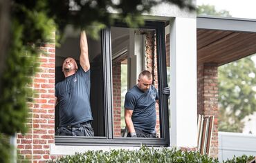 Two installers placing new aluminium profiles in renovated home.